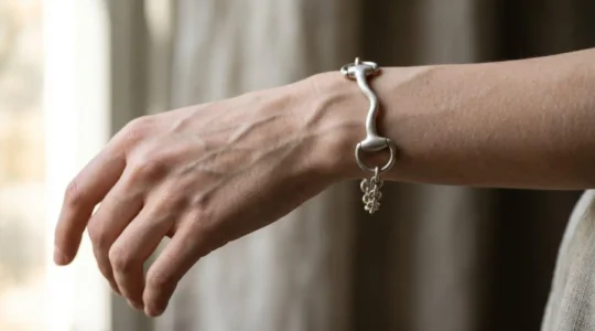Bracelet mors de filet en argent sur un poignet très fin avec anatomie osseuse visible