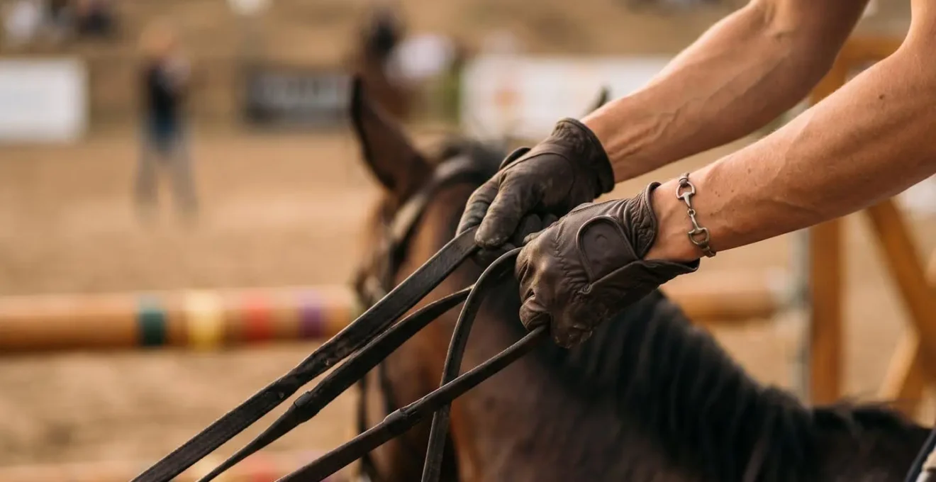 Gros plan sur les mains d'un cavalier tenant les rênes lors d'un parcours d'obstacles équestres